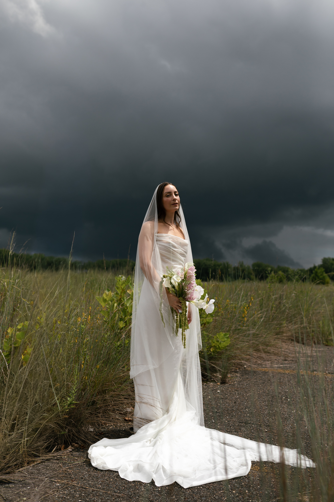TaraBethPhotography2 Tara Beth Photography A bride standing in front of a stormy sky taken by Tara Beth Photography in Philadelphia